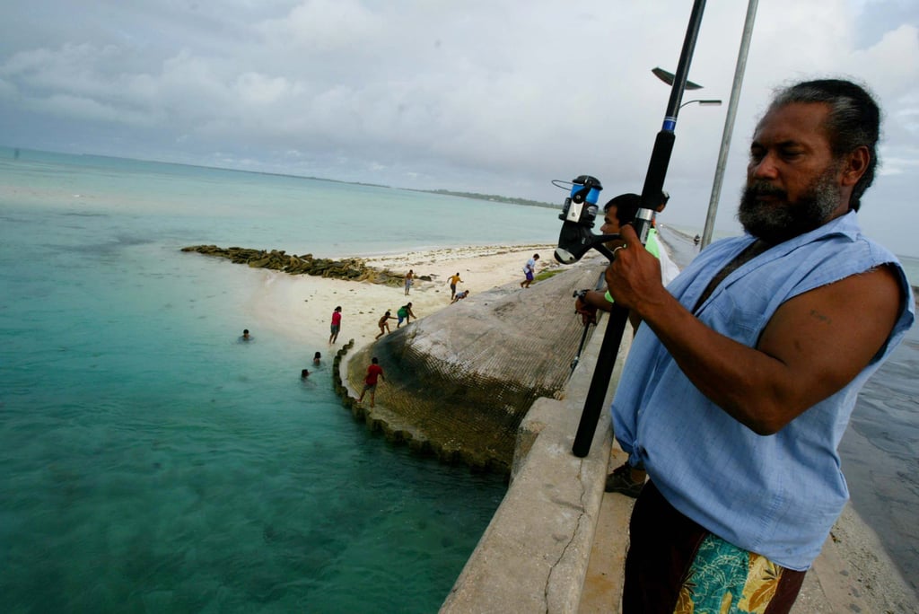 A man fishes on a bridge on Tarawa atoll, Kiribati, in 2004. People on the Pacific islands rely on the ocean for their economic survival. Photo: AP A man fishes on a bridge on Tarawa atoll, Kiribati, in 2004. People on the Pacific islands rely on the ocean for their economic survival. Photo: AP