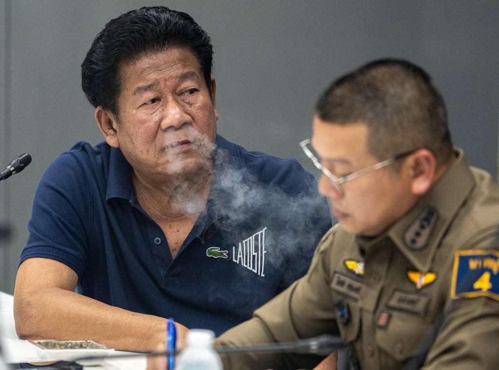 Former lawmaker Chalong Riewrang is questioned by police officers on Monday. Photo: Reuters