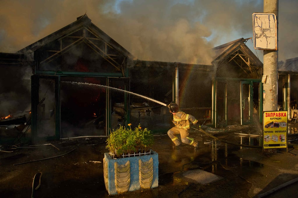 Firefighters try to put out a fire at a city book market following a Russian missile attack in Kyiv on Sunday. Photo: AP