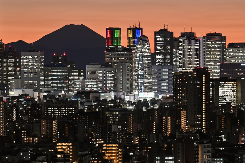 Mount Fuji is silhouetted during sunset behind the high-rise buildings of the Shinjuku area in downtown Tokyo on November 20, 2023. Photo: AFP