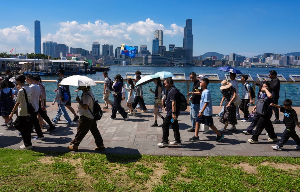 Tourists brave the scorching heat at Wan Chai waterfront. Photo: Jelly Tse