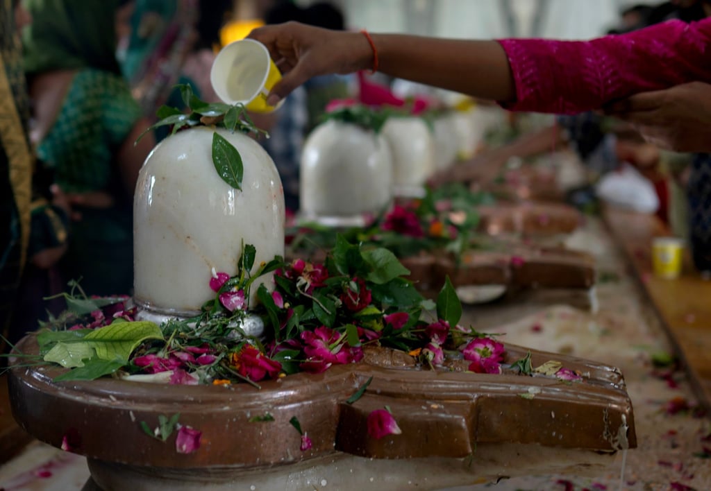 Devotees offer prayers at a row of Shivlings, idols symbolic of Hindu god Shiva at a temple in Prayagraj, Uttar Pradesh state, on August 10. Photo: AP Devotees offer prayers at a row of Shivlings, idols symbolic of Hindu god Shiva at a temple in Prayagraj, Uttar Pradesh state, on August 10. Photo: AP