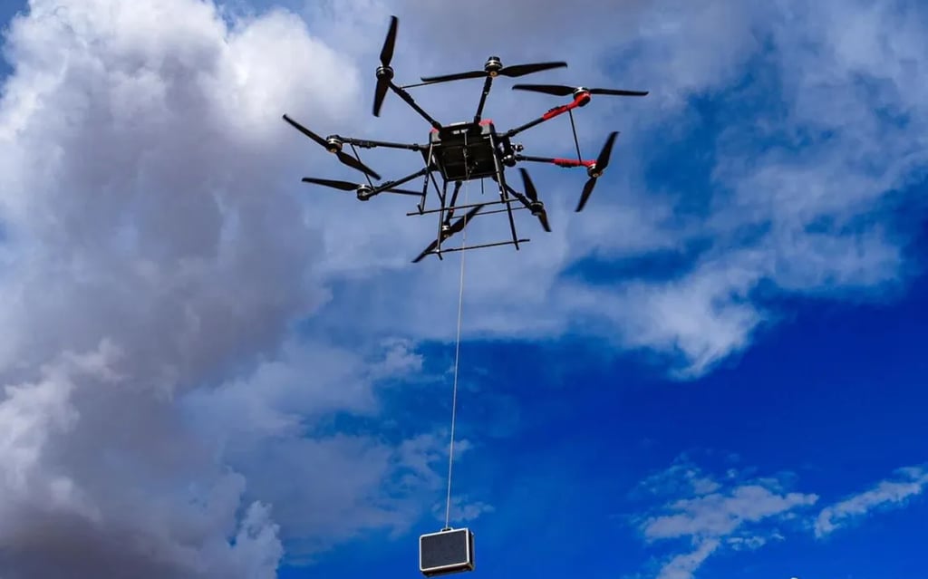 A multi-rotor drone was used to deliver the cases to soldiers in a field. Photo: qq.com A multi-rotor drone was used to deliver the cases to soldiers in a field. Photo: qq.com
