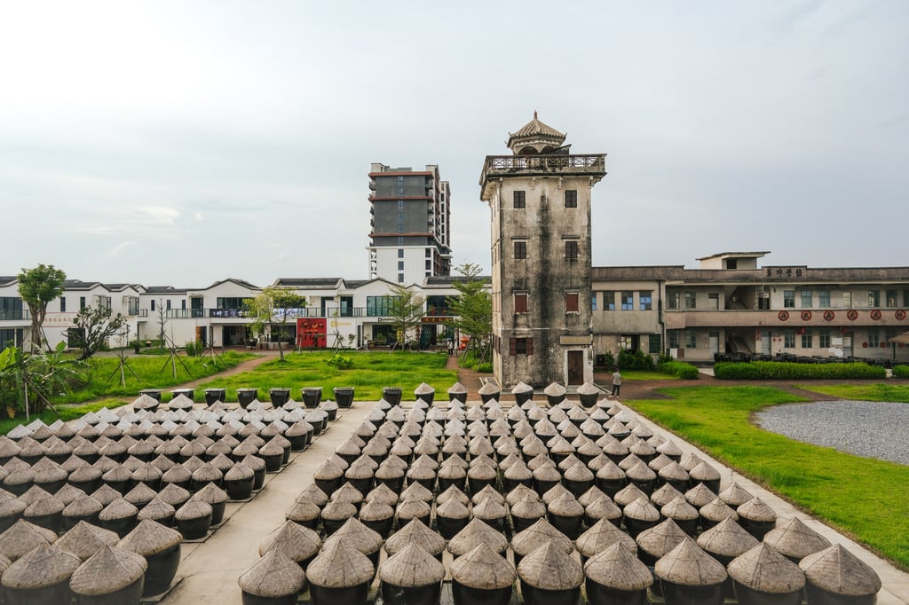 A historic diaolou watchtower behind rows of earthenware jars, at the Hainong Island Sauce Garden in Kaiping. Photo: Hei Kiu Au A historic diaolou watchtower behind rows of earthenware jars, at the Hainong Island Sauce Garden in Kaiping. Photo: Hei Kiu Au