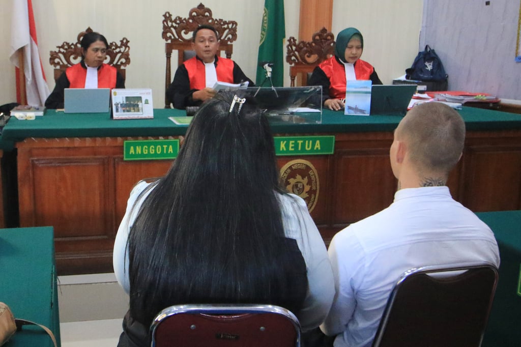 Swiss tourist Luzian Andrin Zgraggen (right, back to camera) sits on the defendant’s chair with an interpreter during his sentencing hearing at the district court in Bali on Thursday. Photo: AP