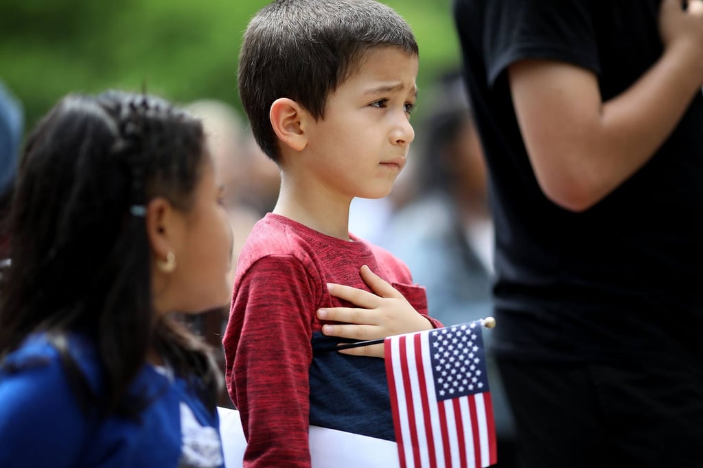 Children say the pledge of allegiance during a children’s citizenship ceremony hosted by US Citizenship and Immigration Services in 2018. Photo: Getty Images/AFP
