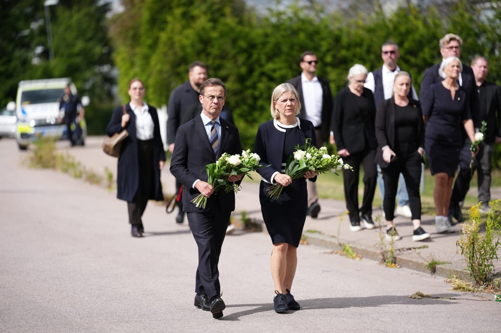 Sweden’s Prime Minister Ulf Kristersson (left) and Social Democratic Party leader Magdalena Andersson visit the makeshift memorial outside a school in Fagersta, Sweden, on Saturday. Photo: AP
