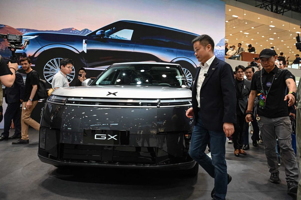Xpeng CEO He Xiaopeng walks past his firm’s new SUV GX six-seater on the opening day of the Beijing Auto Show on April 24, 2026. Photo: AFP