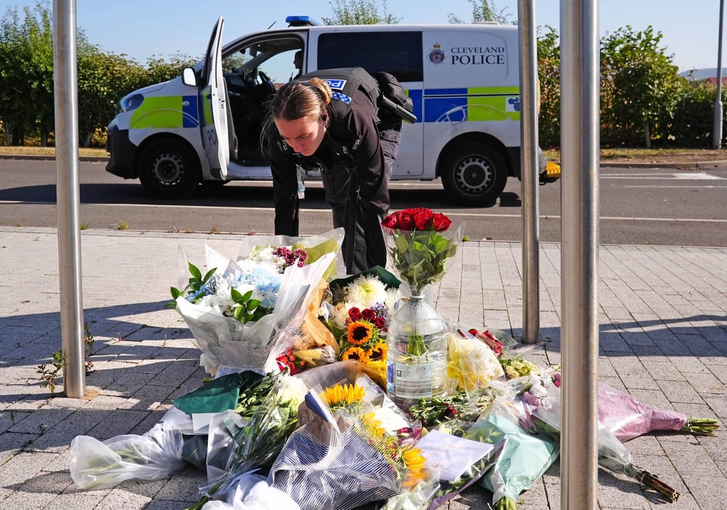 A police officer leaves flowers at the Cleveland Police HQ Memorial Garden in Middlesbrough on Monday, after two officers were killed when a car pursued by police crashed while driving the wrong way on a major road. Photo: dpa A police officer leaves flowers at the Cleveland Police HQ Memorial Garden in Middlesbrough on Monday, after two officers were killed when a car pursued by police crashed while driving the wrong way on a major road. Photo: dpa