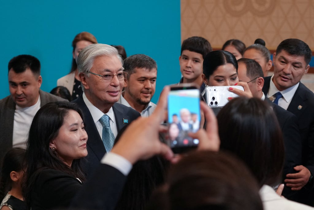 Tokayev poses for a picture with voters at a polling station during a snap parliamentary election in Astana, Kazakhstan, on Sunday. Photo: Reuters