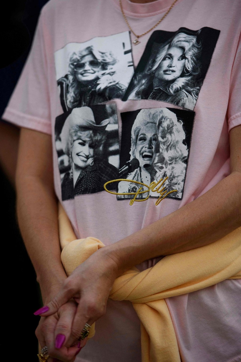 A fan pays tribute to Dolly Parton by wearing a T-shirt bearing images of the music superstar at her statue in Sevierville, Tennessee, on August 25. Photo: Getty Images/AFP A fan pays tribute to Dolly Parton by wearing a T-shirt bearing images of the music superstar at her statue in Sevierville, Tennessee, on August 25. Photo: Getty Images/AFP