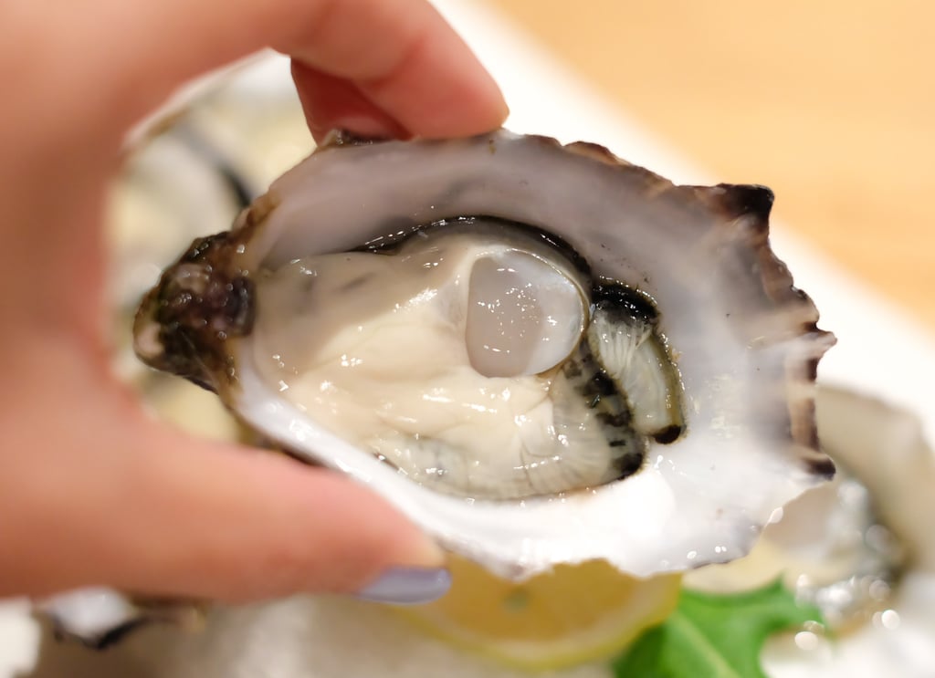 A woman prepares to eat an oyster. There is a big demand for oysters around Christmas in Australia. Photo: Shutterstock A woman prepares to eat an oyster. There is a big demand for oysters around Christmas in Australia. Photo: Shutterstock