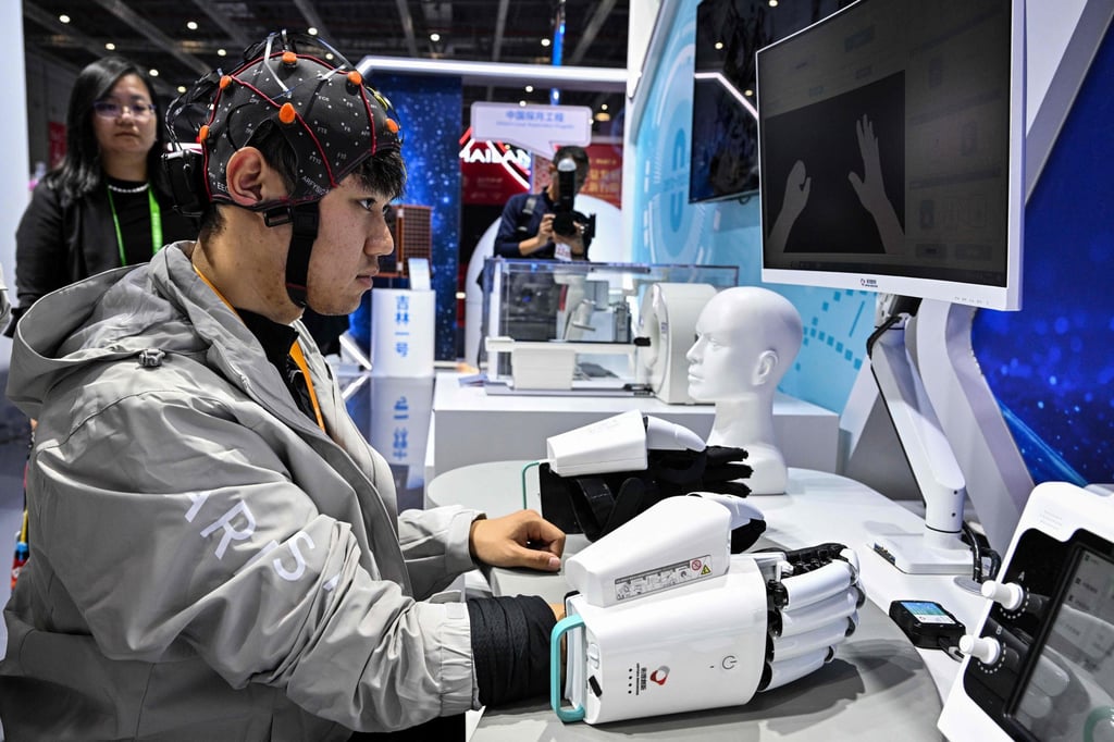A man demonstrates a robotic hand with a brain-computer interface, which identifies the patient’s motor signals and controls the exoskeleton to move the limbs of the patient, during the 8th China International Import Expo in Shanghai on November 7. Photo: AFP A man demonstrates a robotic hand with a brain-computer interface, which identifies the patient’s motor signals and controls the exoskeleton to move the limbs of the patient, during the 8th China International Import Expo in Shanghai on November 7. Photo: AFP