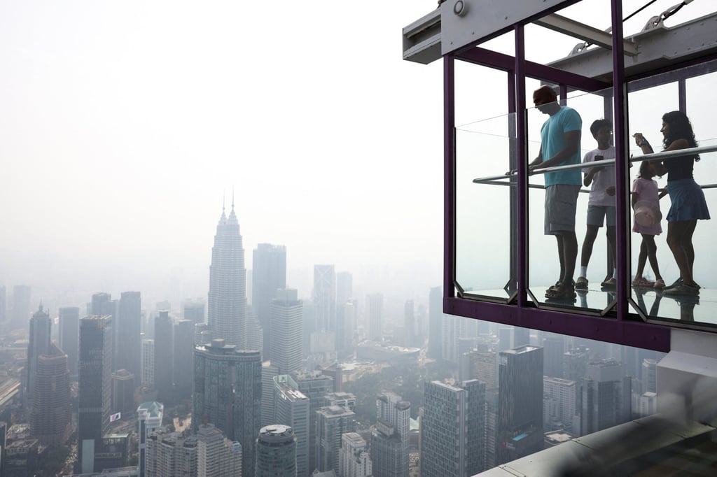 Tourists look at the skyline of Kuala Lumpur shrouded in haze from Indonesia’s wildfires earlier this month. Photo: Reuters Tourists look at the skyline of Kuala Lumpur shrouded in haze from Indonesia’s wildfires earlier this month. Photo: Reuters