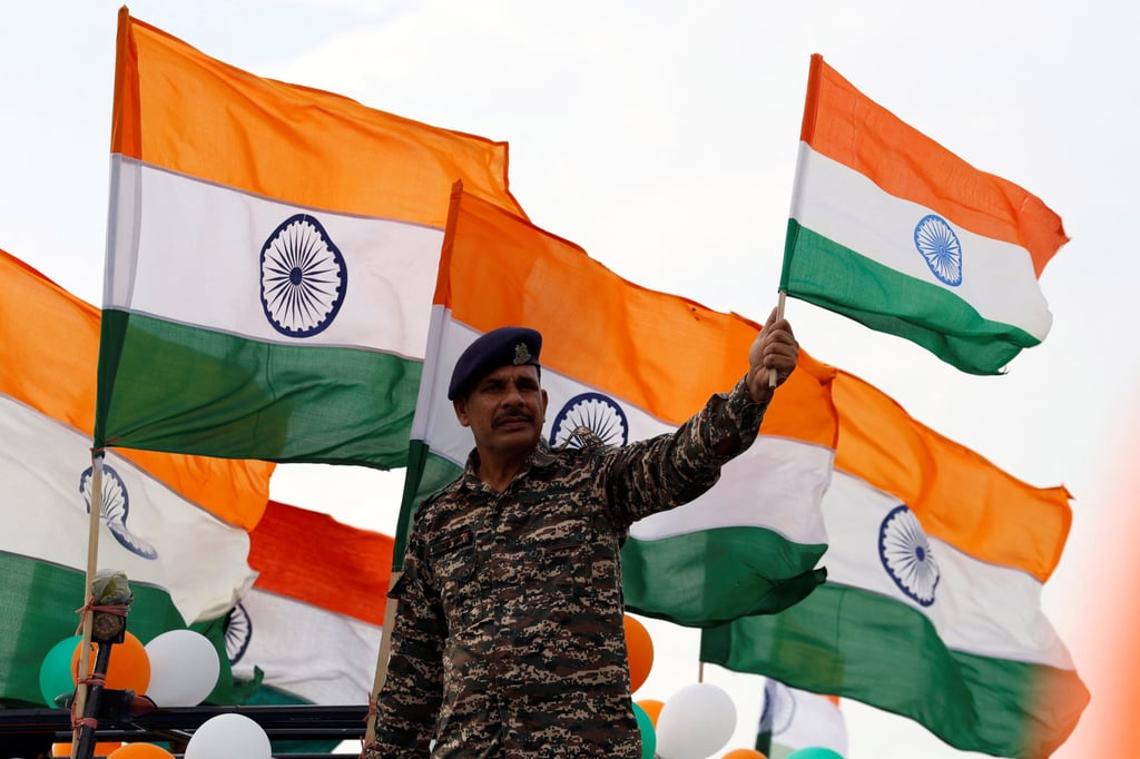 A paramilitary policeman waves India’s national flag in Srinagar, Indian-administered Kashmir, on August 14, the eve of the country’s Independence Day celebrations. Photo: Reuters