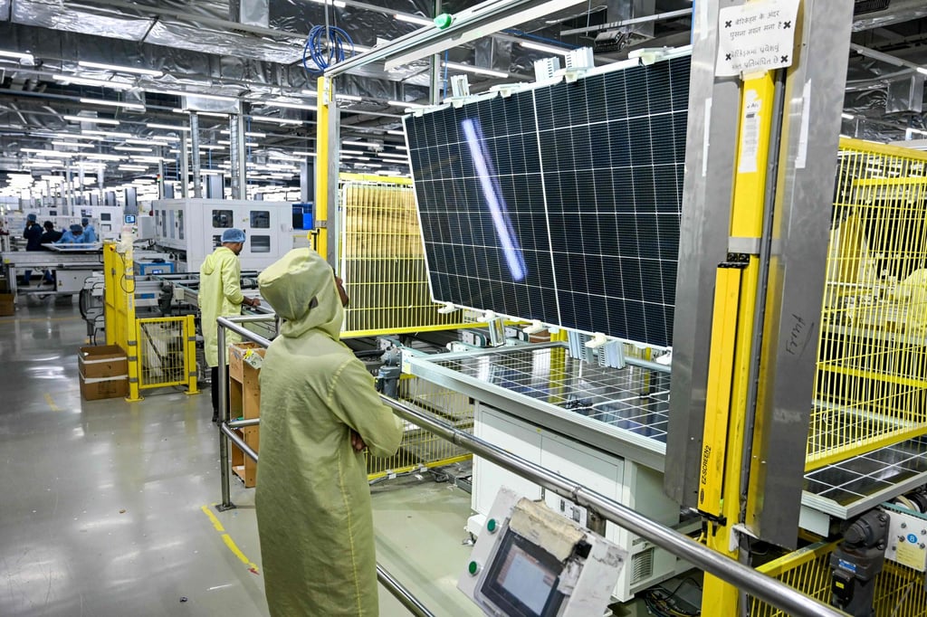 Empleados inspeccionan paneles solares en una fábrica en la ciudad portuaria de Mundra, Gujarat, India. Foto: AFP