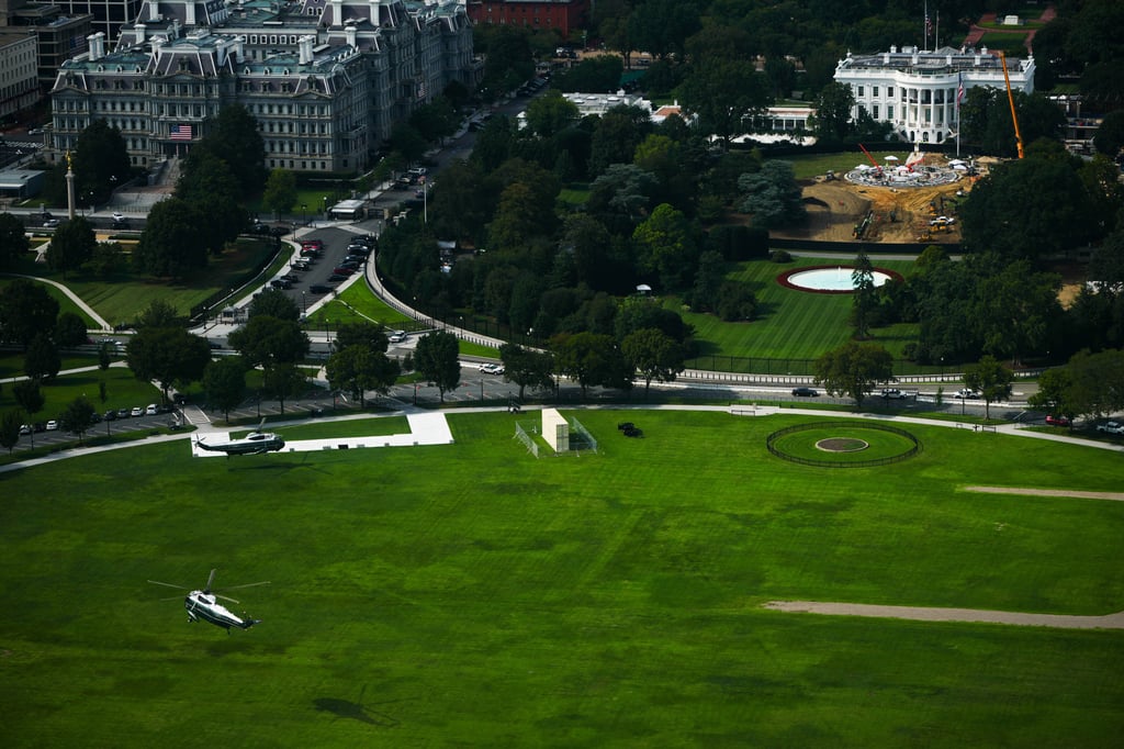 Marine One, right, and a presidential support helicopter, left, arrive on the Ellipse as construction takes place at the White House. Photo: AP