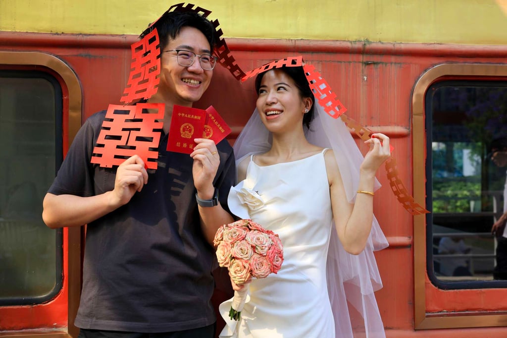 Newlyweds pose for a photo with their marriage certificates and a red wedding decoration at the registry office on May 20, a date that sounds like “I love you” in Chinese, in Chengdu, Sichuan province. Although red is a lucky colour in Chinese culture, contemporary Chinese brides increasingly prefer to wear white. Photo: China News Service via Getty Images