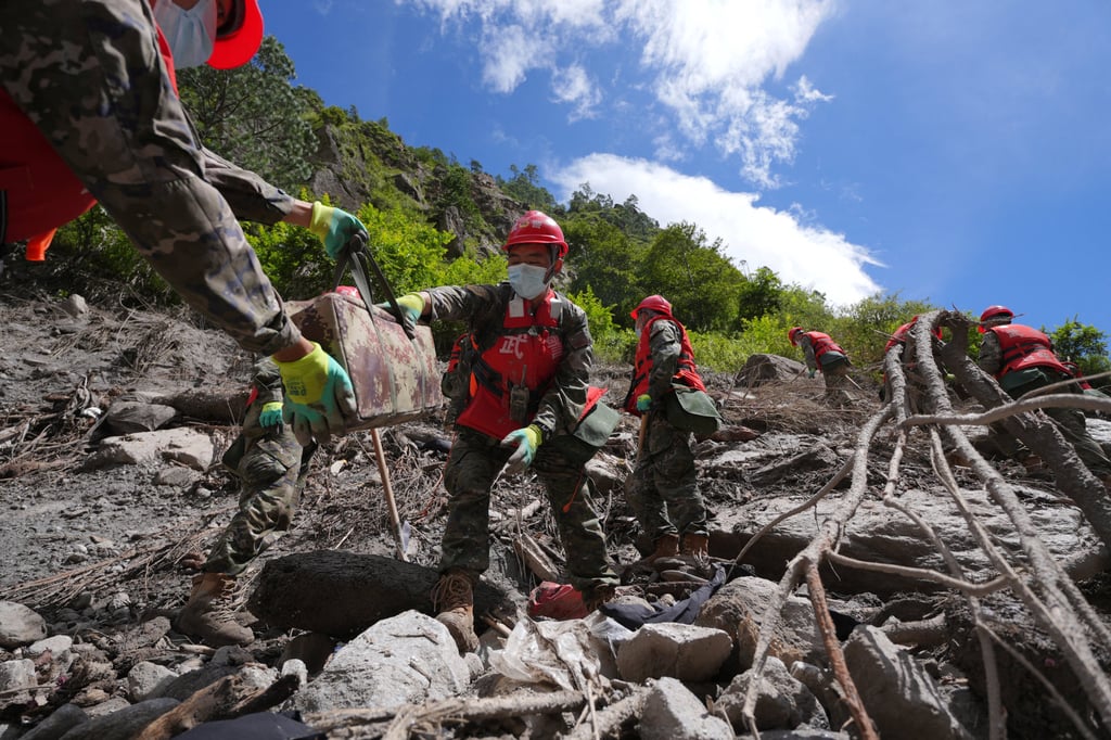 Chinese People’s Armed Police officers clear debris near Gyirong Port on Friday. Photo: China Daily via Reuters Chinese People’s Armed Police officers clear debris near Gyirong Port on Friday. Photo: China Daily via Reuters