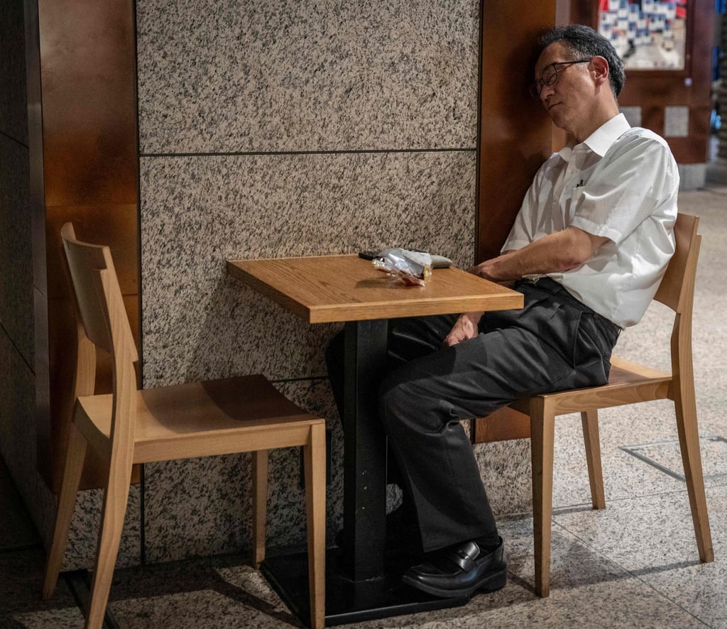 A man sleeps on a chair inside a commercial building in Tokyo on Tuesday. Photo: AFP