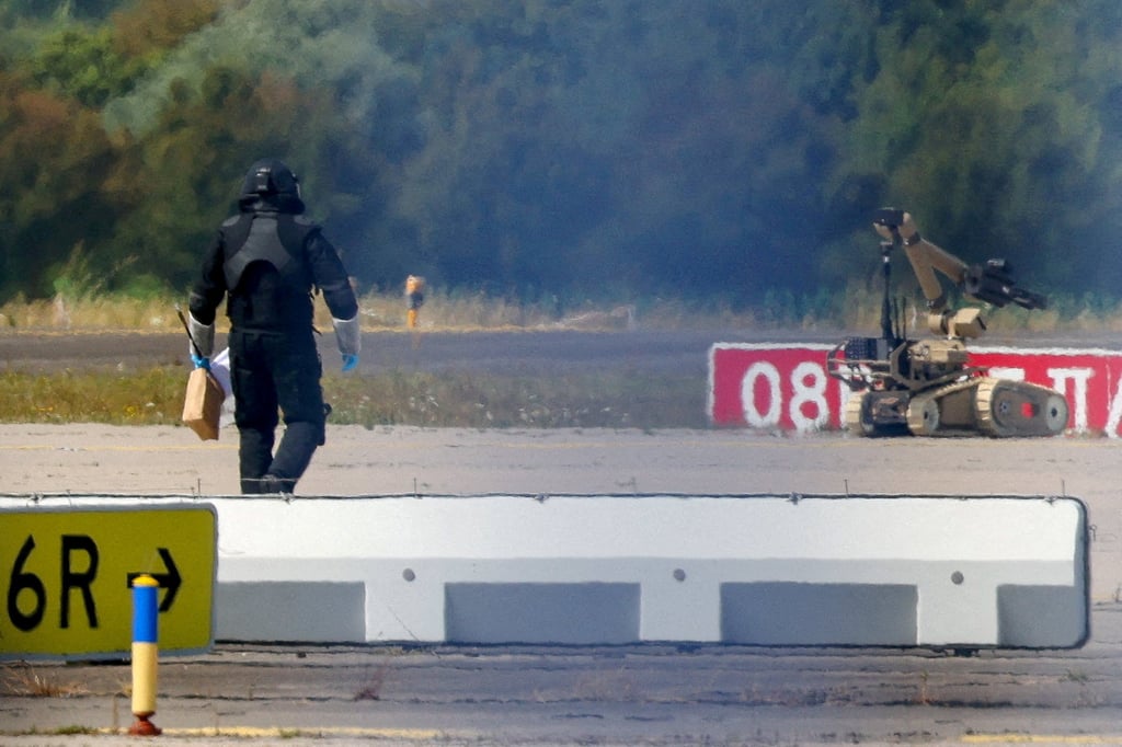 A police officer in protective clothing walks next to an explosive-disarming robot at Leipzig/Halle Airport in August. Photo: Reuters
