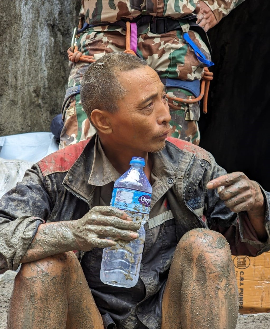 A Chinese survivor sits with a bottle of water after being pulled out of a tunnel in Nepal on Saturday. Photo: Army handout via EPA A Chinese survivor sits with a bottle of water after being pulled out of a tunnel in Nepal on Saturday. Photo: Army handout via EPA