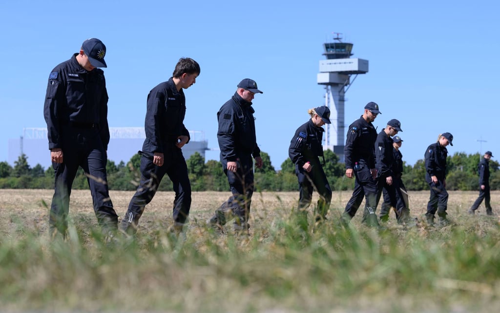 Police officers search a field at Germany’s Leipzig/Halle Airport following a drone incident. Photo: dpa