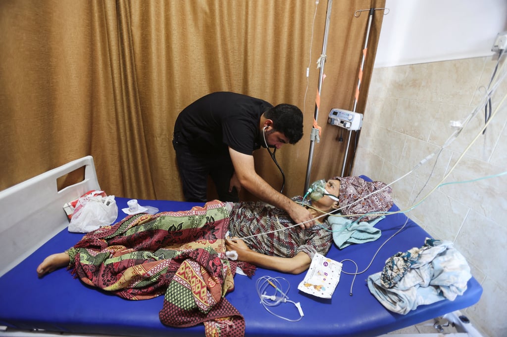 Palestinian internal medicine doctor Ahmed Al-Nabris puts an oxygen mask on a female patient at Nasser Hospital in Khan Younis, in the southern Gaza Strip, on September 3. Photo: Reuters
