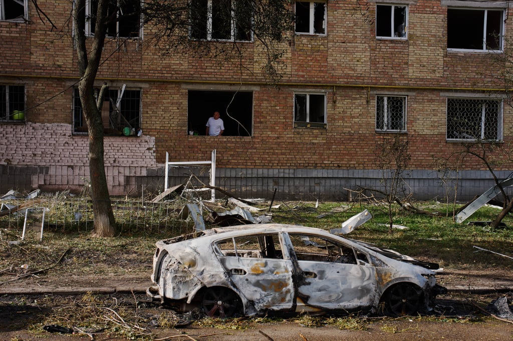A man peers from his apartment in a damaged residential building following a Russian missile and drone attack in Kyiv, Ukraine, on Tuesday. Photo: AP