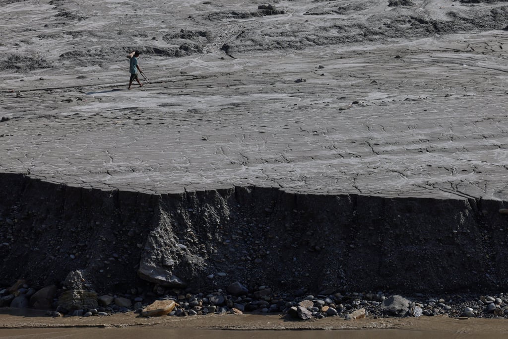 A man walks along a mud-covered riverbank following deadly flash floods and mudslides, in Dhading district, Nepal, on Monday. Photo: Reuters A man walks along a mud-covered riverbank following deadly flash floods and mudslides, in Dhading district, Nepal, on Monday. Photo: Reuters