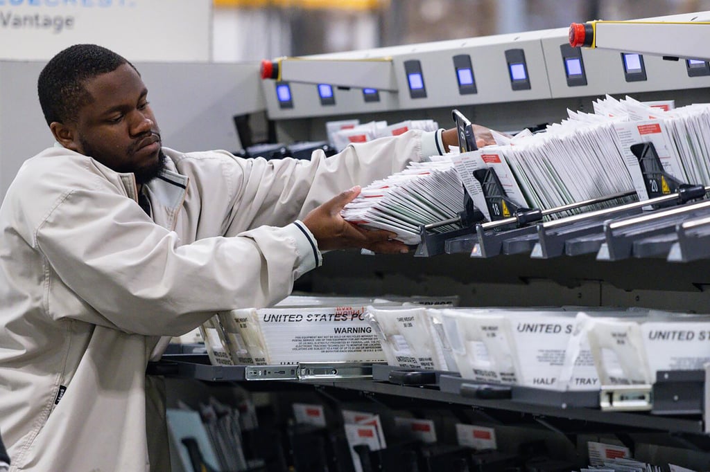 A worker puts ballots in a counting machine at the Los Angeles County Ballot Processing Centre on June 3. Photo: TNS