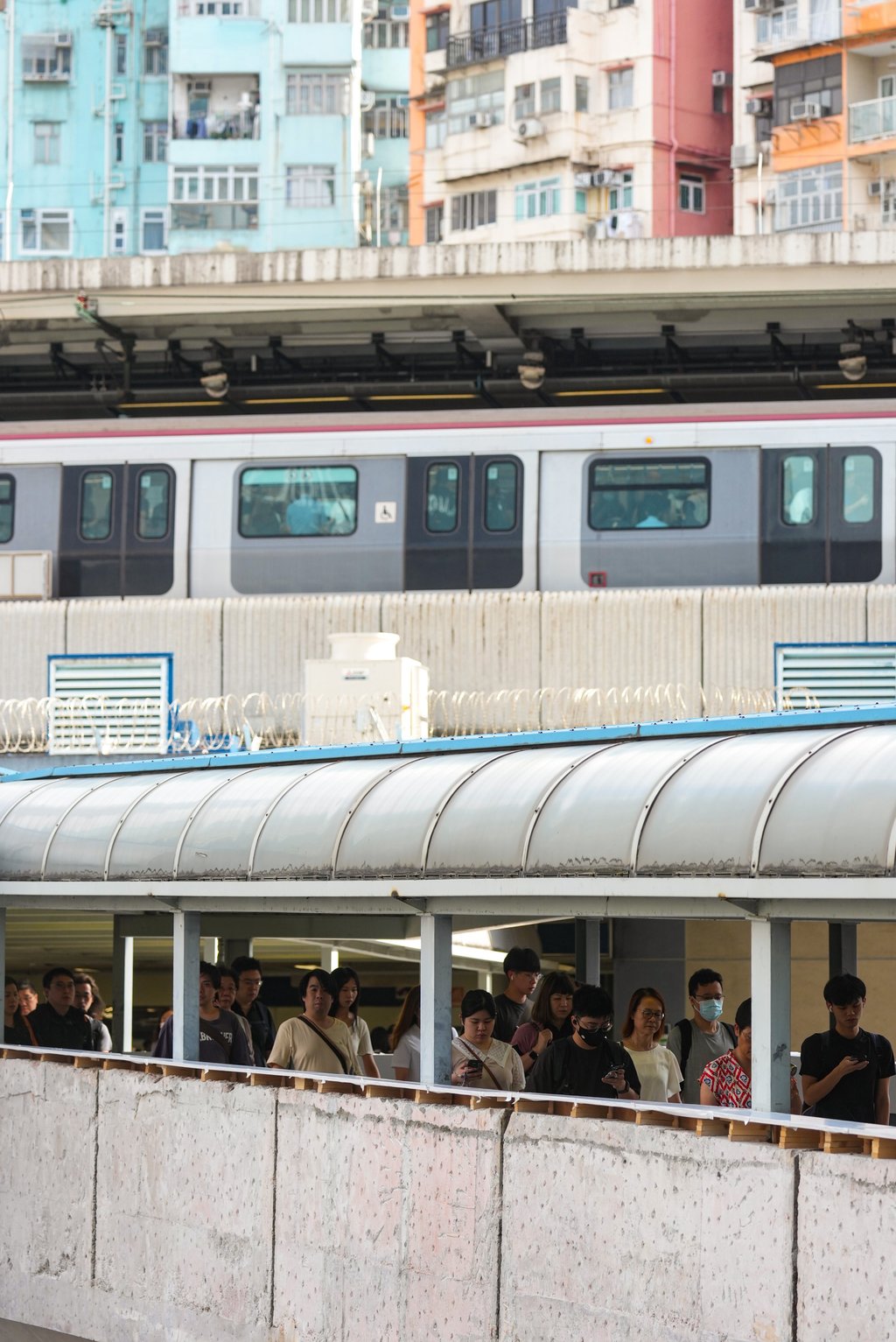 Pedestrians on the footbridge between the MTR station (seen above) and Hoi Yuen Road in Kwun Tong. Photo: Kit Lai Pedestrians on the footbridge between the MTR station (seen above) and Hoi Yuen Road in Kwun Tong. Photo: Kit Lai