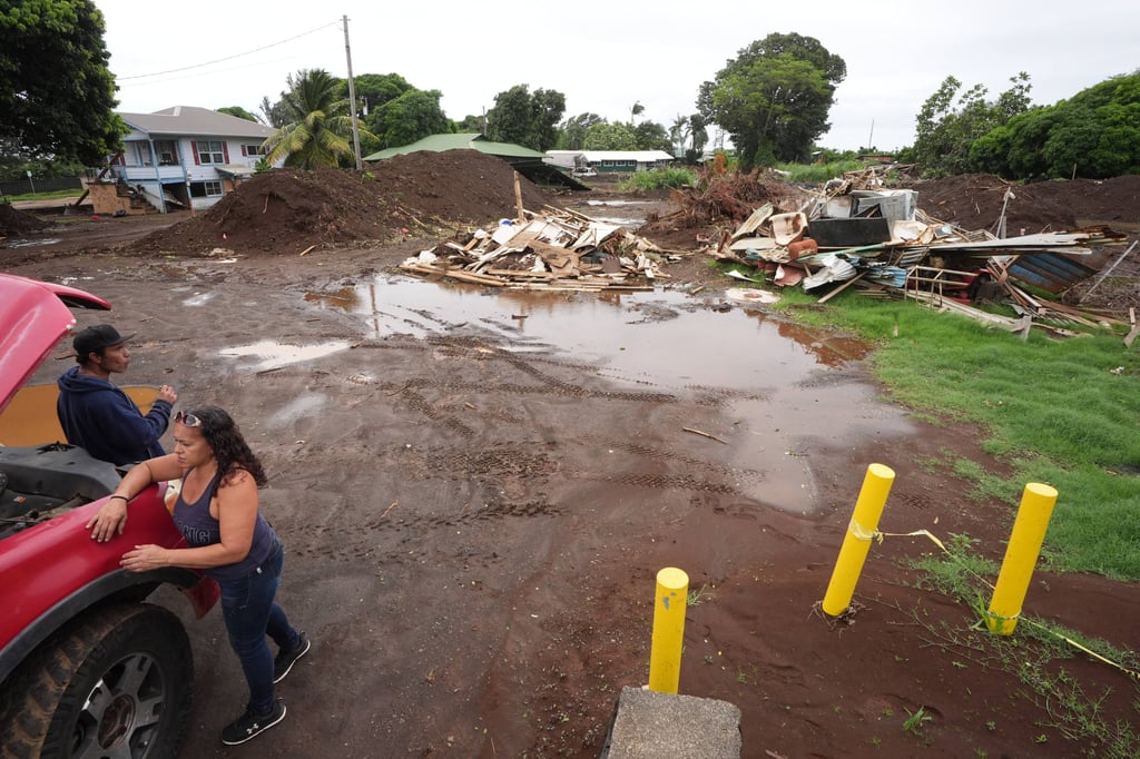 A couple waits for battery cables to start their truck near where a house was destroyed during last month’s Hurricane Lala, as floodwaters from Hurricane Nolo receded on Sunday in Naalehu, Hawaii. Photo: AP A couple waits for battery cables to start their truck near where a house was destroyed during last month’s Hurricane Lala, as floodwaters from Hurricane Nolo receded on Sunday in Naalehu, Hawaii. Photo: AP