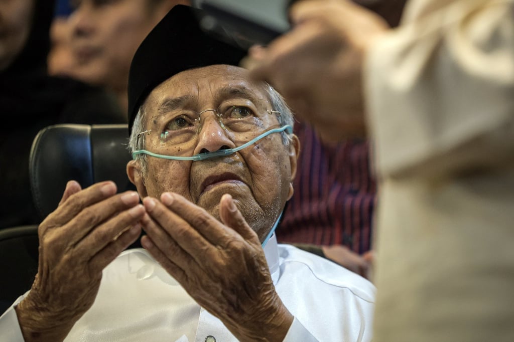 Mahathir Mohamad reacts as friends and relatives pay their respects to his late wife before her funeral procession on Monday. Photo: EPA Mahathir Mohamad reacts as friends and relatives pay their respects to his late wife before her funeral procession on Monday. Photo: EPA