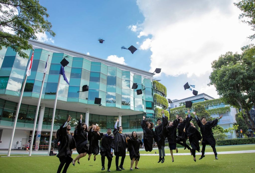 Singapore Management University graduates celebrate by throwing their mortarboards in the air. Photo: Singapore Management University
