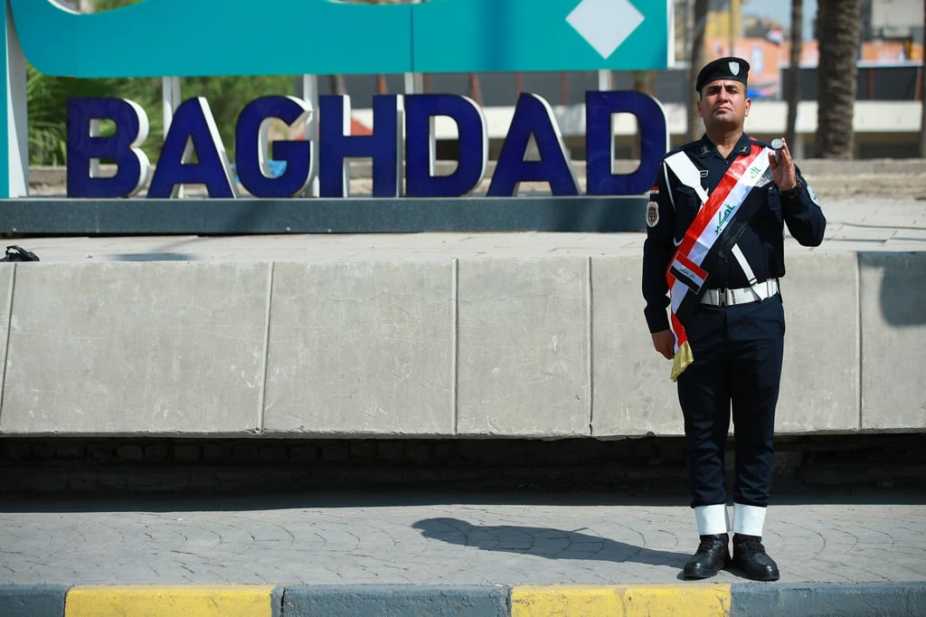 An Iraqi soldier stands in front of a Baghdad sign celebrating the withdrawal of US troops on Wednesday. Photo: dpa