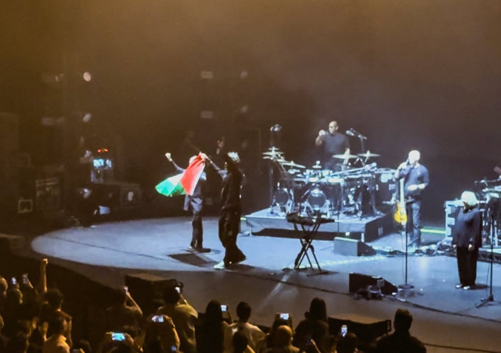 Robert Del Naja and Grant Marshall from Massive Attack stand with a Palestinian flag onstage at the end of their performance in Singapore on July 29. Photo: Simran Panaech via Reuters