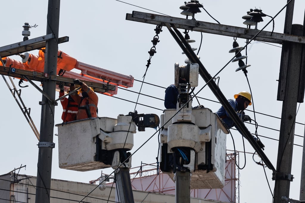 Workers from an electricity distribution company conduct repairs on power lines in Quezon City in March. The Philippines is taking steps to integrate nuclear power into its energy mix. Photo: EPA