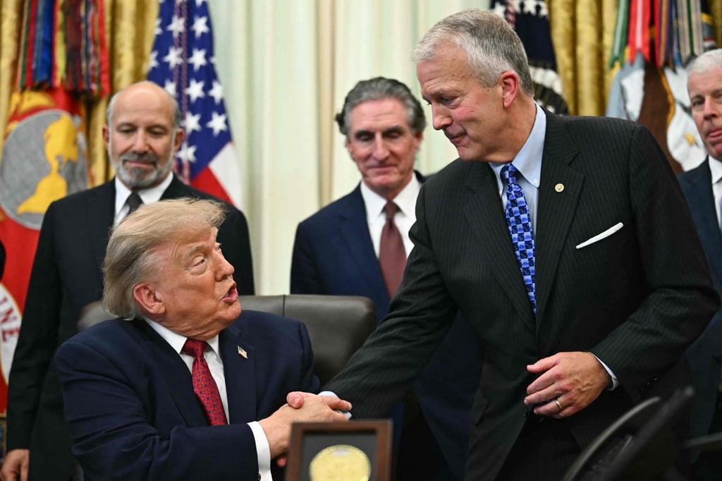US President Donald Trump (seated) shakes hands with Senator Dan Sullivan as he makes an announcement about Alaska LNG on Wednesday. Photo: AFP