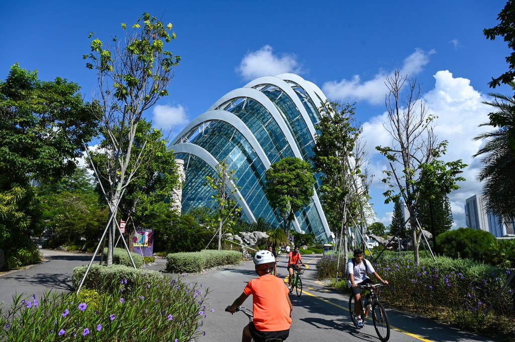 People cycle along a path next to the Flower Dome in the Gardens by the Bay. Singapore aims to have 1,300km of cycle paths by 2030. Photo: AFP