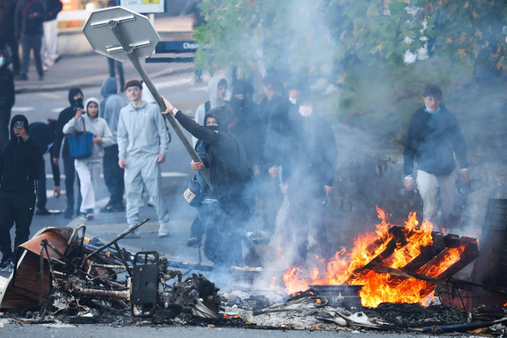 A protester throws a stop sign into a fire near the Kerichen high school in Brest, western France, on Friday. Photo: AFP A protester throws a stop sign into a fire near the Kerichen high school in Brest, western France, on Friday. Photo: AFP