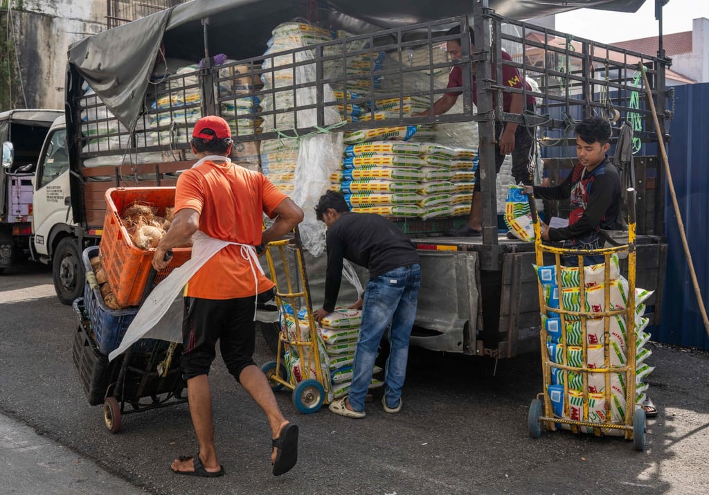 Workers unload sacks of rice outside a market in Kuala Lumpur on April 28. Photo: AFP