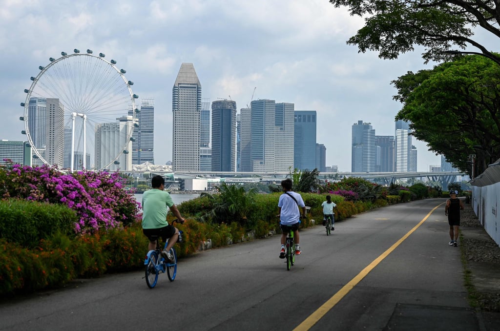 Cyclists ride along a track in Singapore with the city skyline in the background. Cycling is still mainly used for recreation in the city state. Photo: AFP