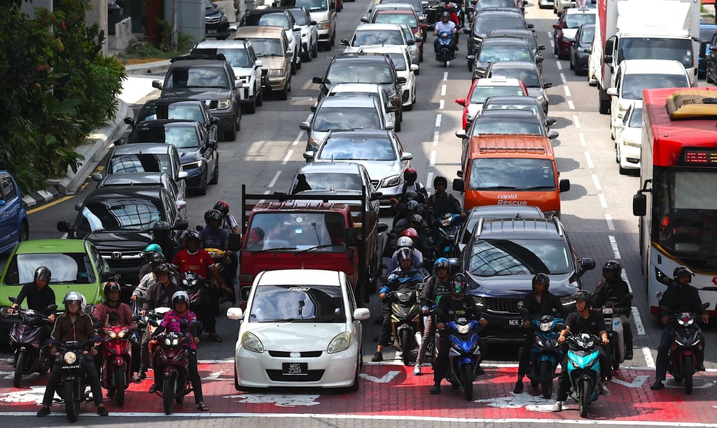 Commuters wait at a traffic light in Kuala Lumpur on May 12. Photo: EPA