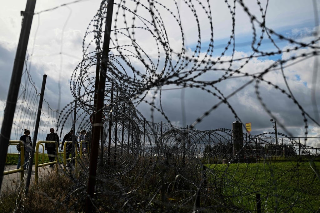 Tourists stand next to a razor wire fence along the Polish-Lithuanian border with the Russian exclave of Kaliningrad in September. Photo: AFP Tourists stand next to a razor wire fence along the Polish-Lithuanian border with the Russian exclave of Kaliningrad in September. Photo: AFP