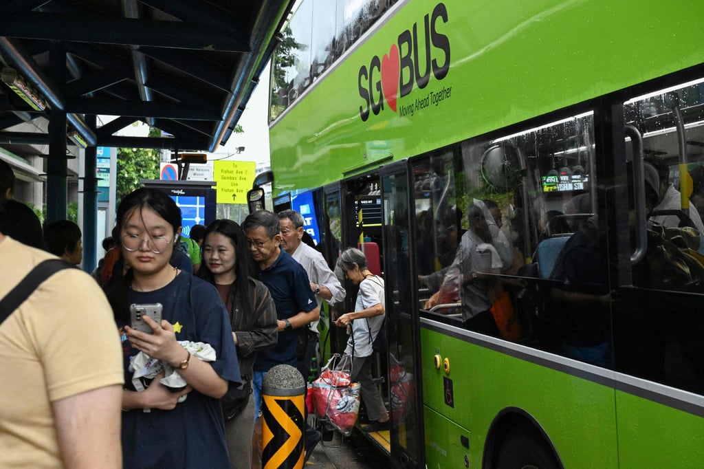 People alight from a bus in Singapore on September 21. Since 2018, only the number of goods vehicles and buses on Singapore’s roads has increased, according to government figures. Photo: AFP