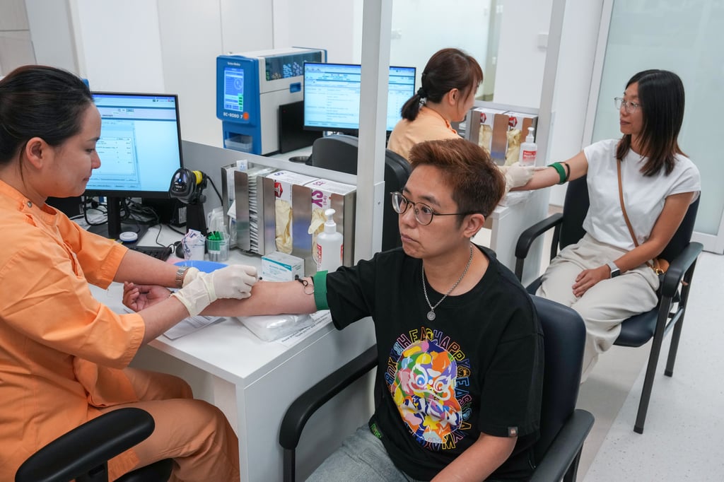 Kai Tak Hospital staff demonstrate the blood-taking process inside the Blood Taking Station. Photo: Kit Lai