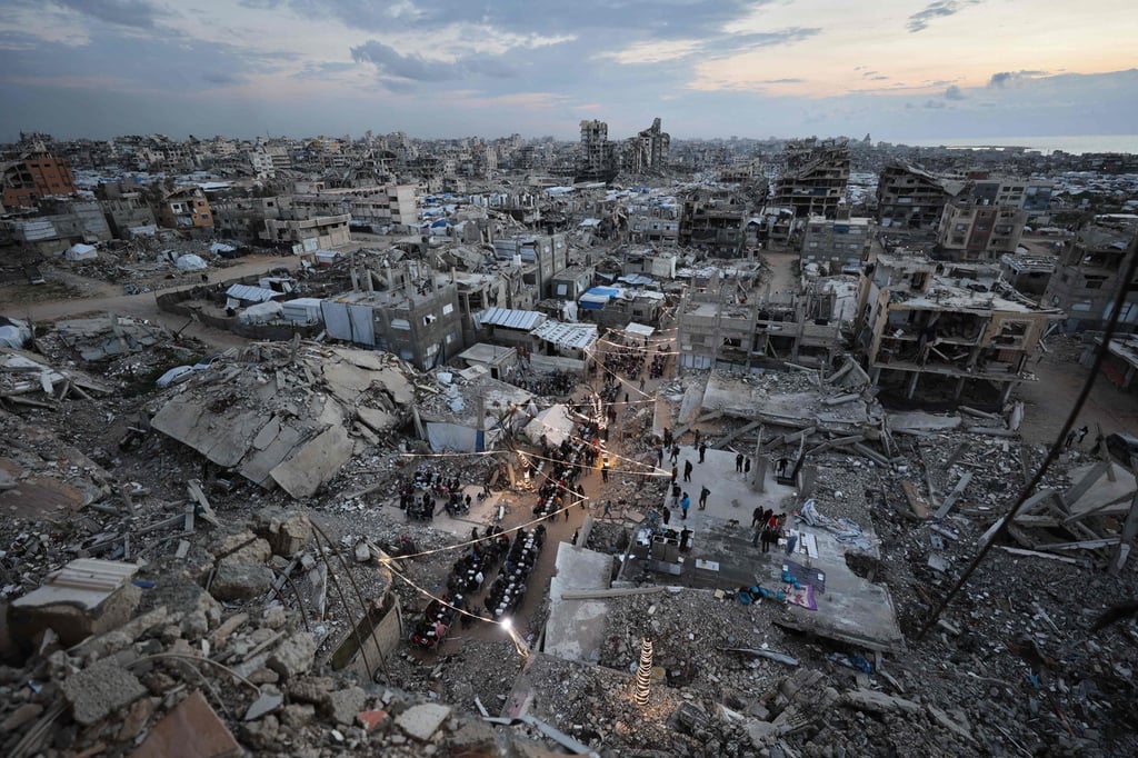 Displaced Palestinians gather for their fast-breaking Iftar meal amid the rubble of destroyed buildings at the Jabalia refugee camp in the northern Gaza Strip on February 23. Photo: AFP