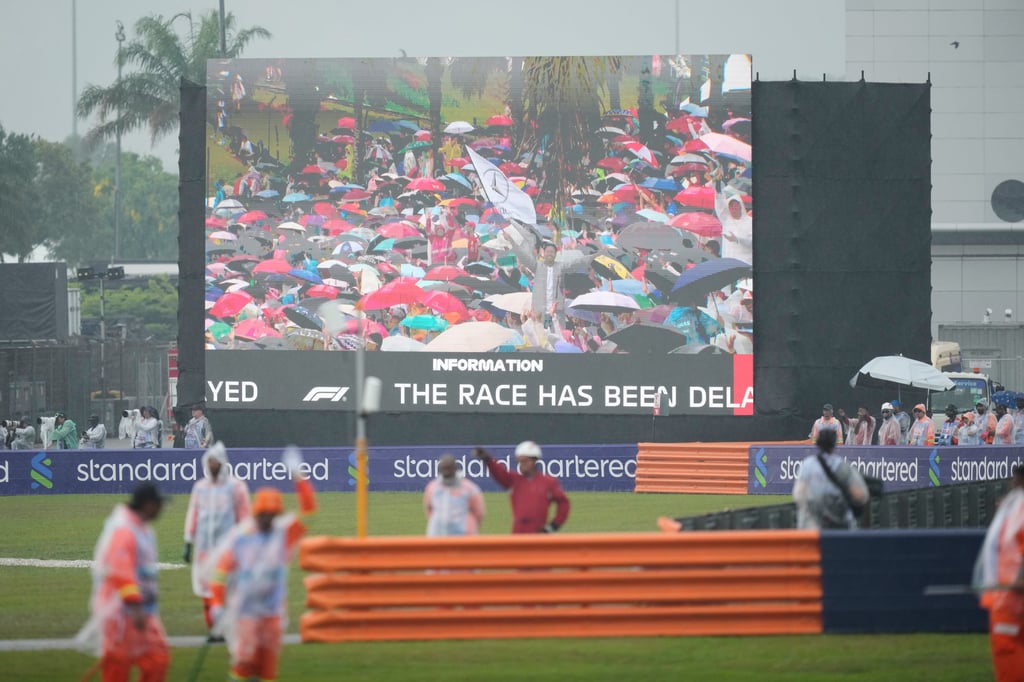 A giant screen shows spectators sheltering from heavy rain before the start of the Bahrain Grand Prix in Sepang, Malaysia, on Sunday. Photo: AP