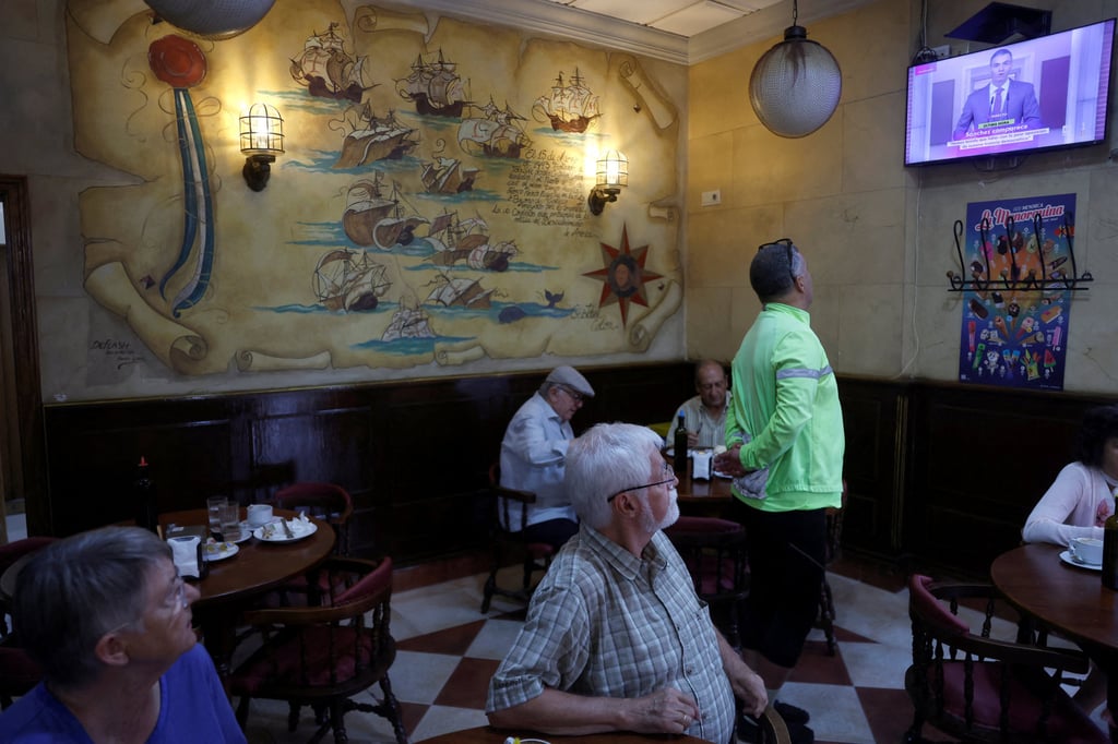 Spaniards watch Prime Minister Pedro Sanchez announce the snap election on television. Photo: Reuters